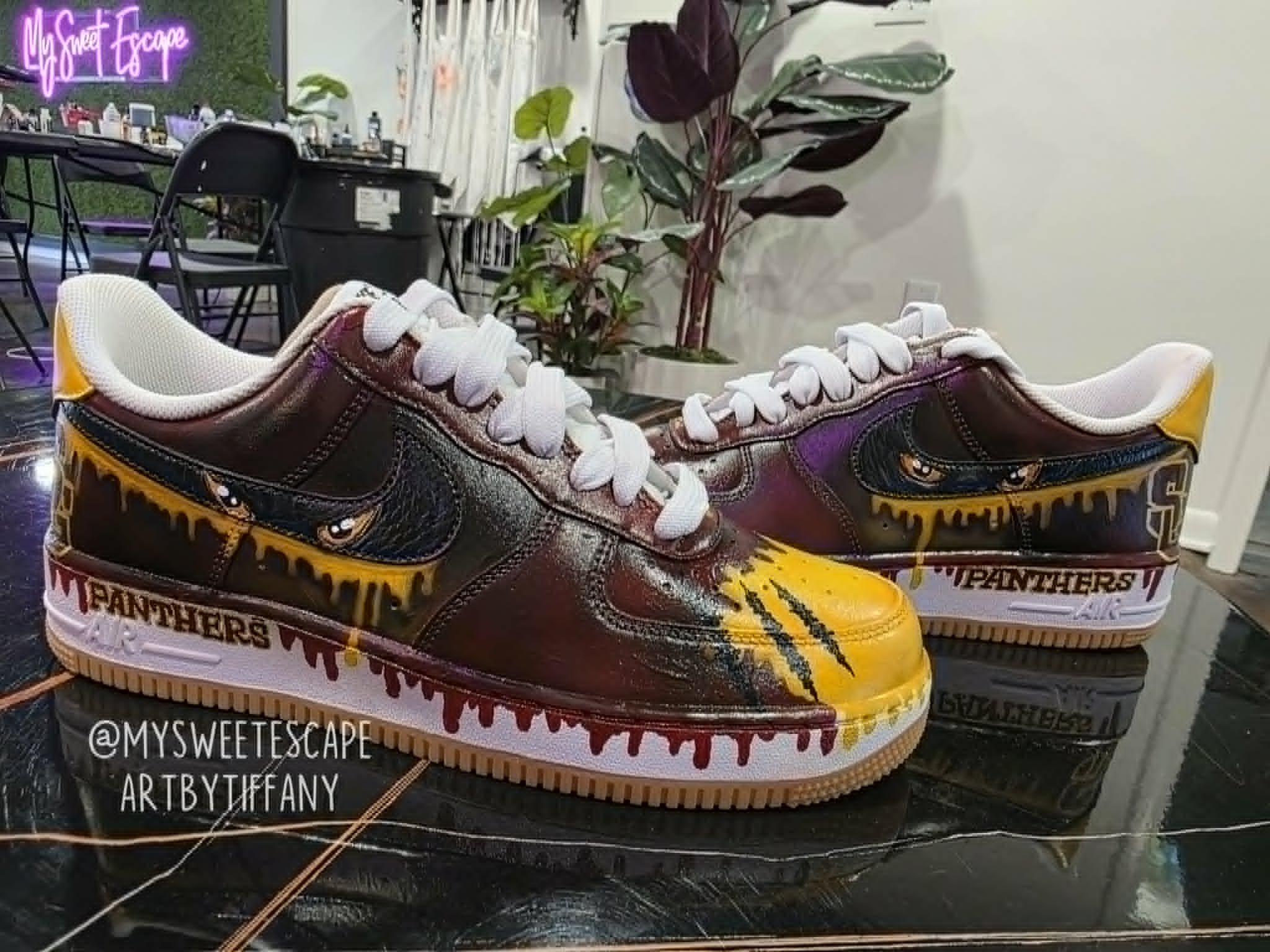 Hand-painted Spring Garden Panthers Nike Air Force 1 sneakers in maroon and gold with dripping panther eyes, claw scratch marks, and 'Panthers' team lettering along the midsole