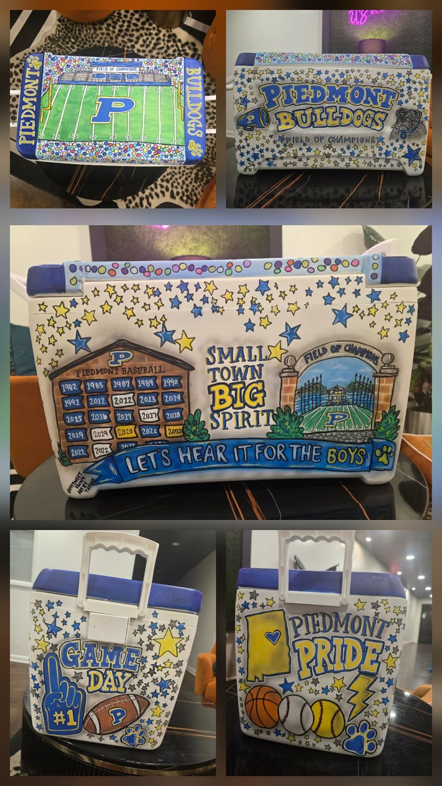 Hand-painted Piedmont Bulldogs cooler collage in blue and gold showing the Field of Champions football field on the lid, 'Small Town Big Spirit' with the baseball championship banners, 'Game Day' and 'Piedmont Pride' side panels, and stars and paw prints