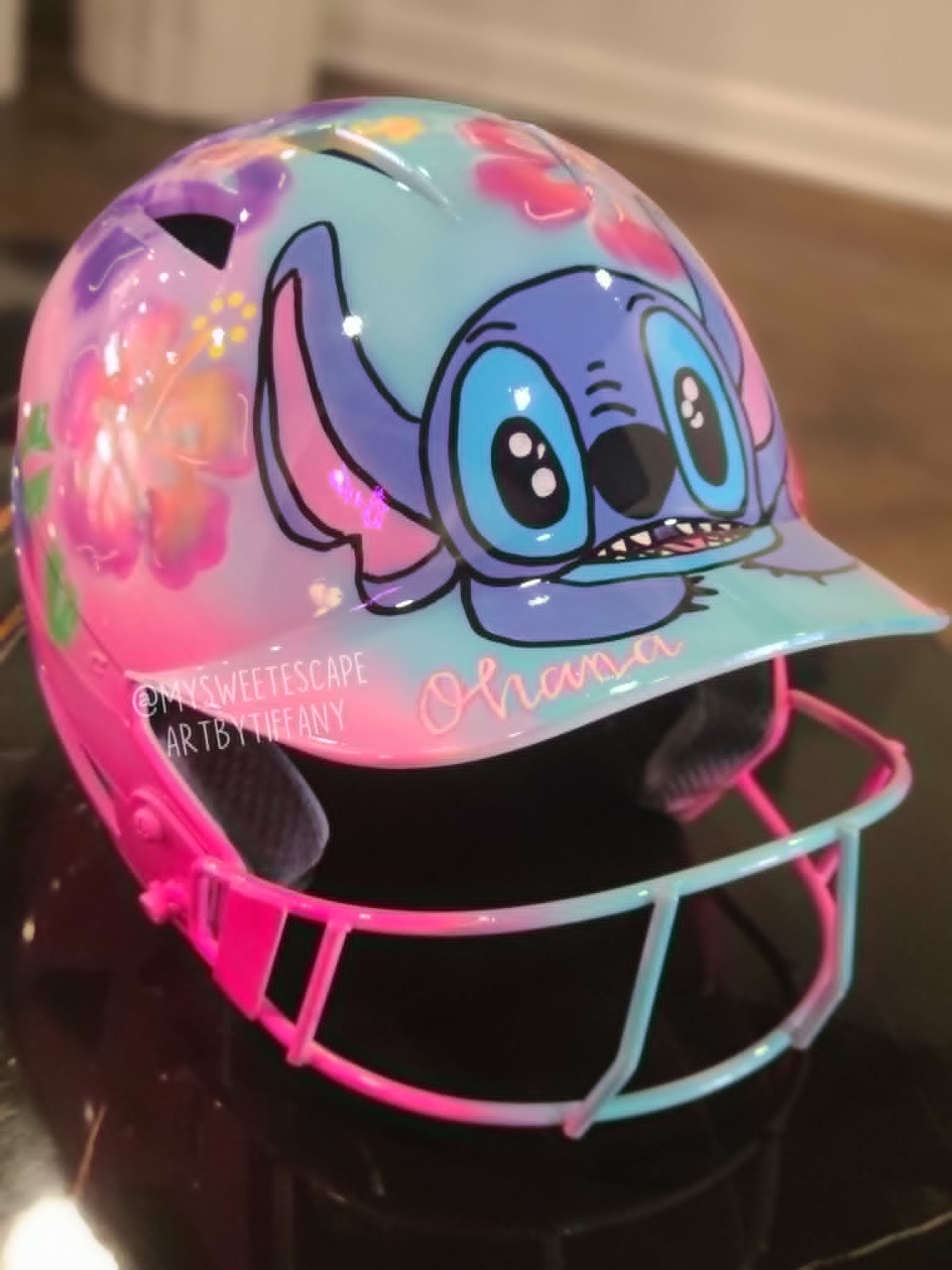 Custom airbrushed pastel softball helmet with blue alien character, tropical hibiscus flowers, and Ohana script