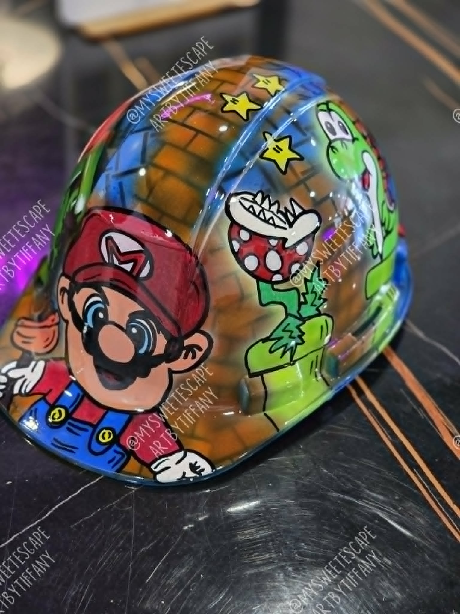 Custom hand-painted hard hat with retro video game scene featuring a plumber character, dinosaur, piranha plant, and gold stars on a brick background