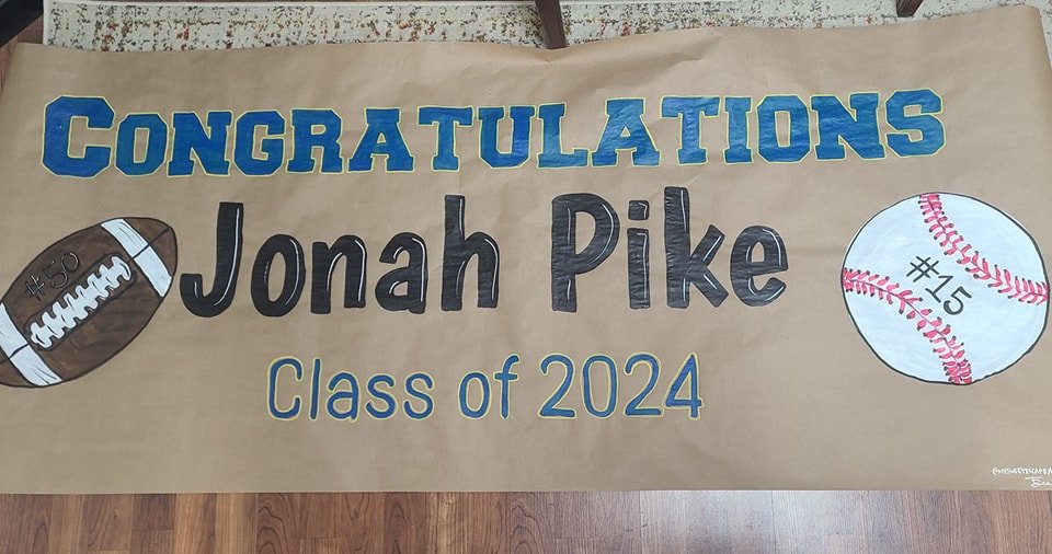 Hand-painted graduation banner reading 'Congratulations Jonah Pike, Class of 2024' with painted football jersey number 50 and baseball number 15