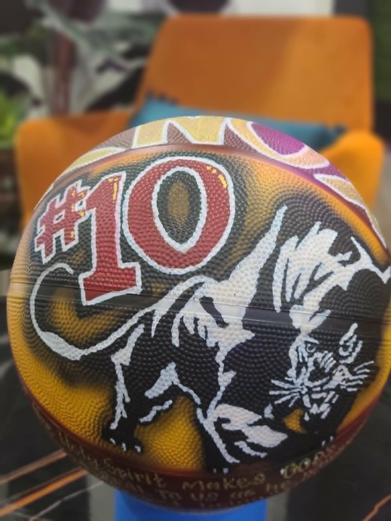 Hand-painted basketball with bold red '#10' lettering and silhouette of a panther mascot in black, gold, and red