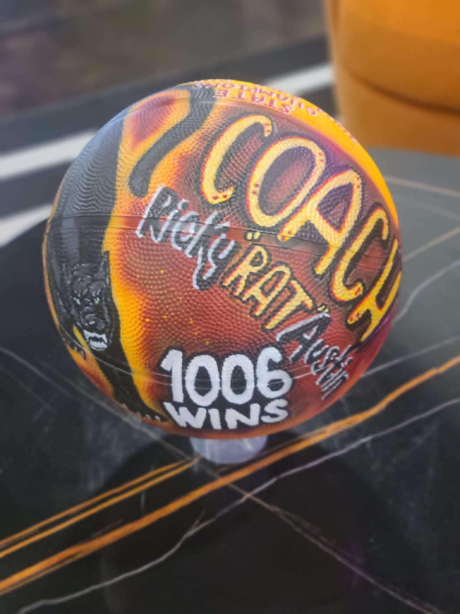Hand-painted coach's basketball for Coach Ricky 'Rattan' Austin commemorating 1006 wins, with panther mascot and orange and black flame design
