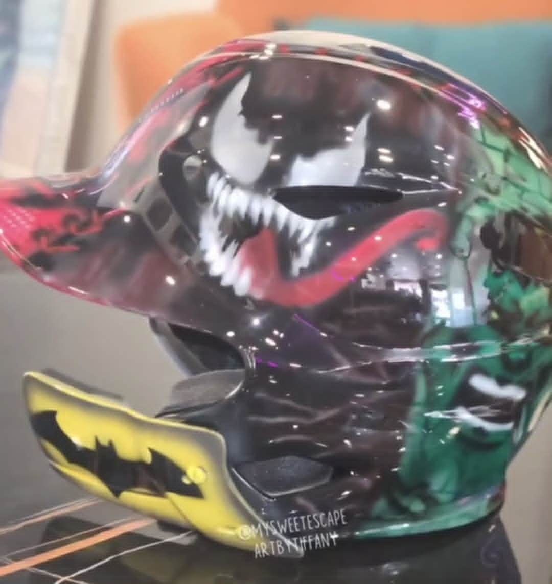 Custom airbrushed batting helmet featuring Venom on one side and the Hulk on the other, with a yellow Batman logo on the ear flap