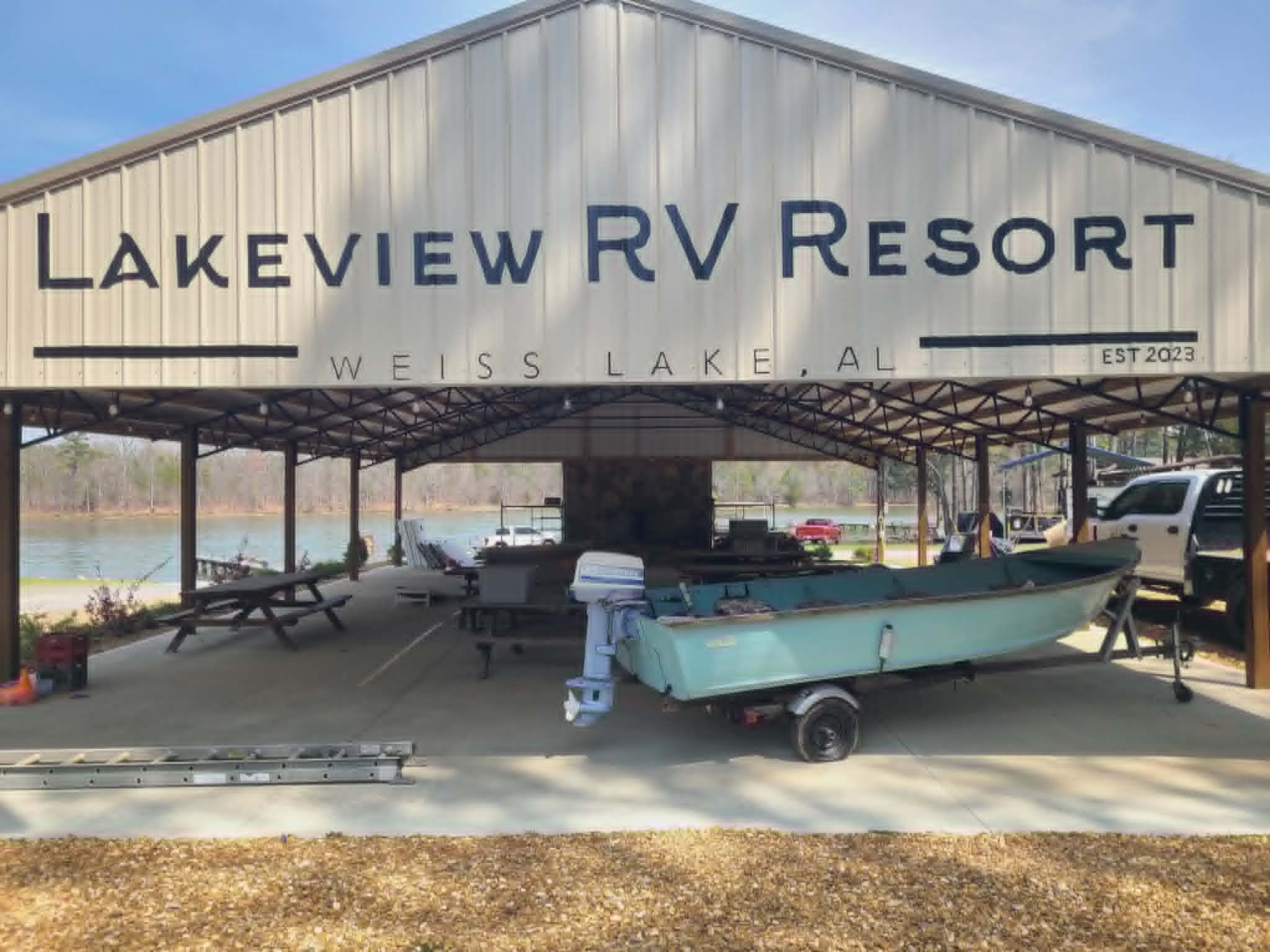 Large hand-painted 'Lakeview RV Resort — Weiss Lake, AL Est 2023' sign in modern serif lettering on a metal building exterior