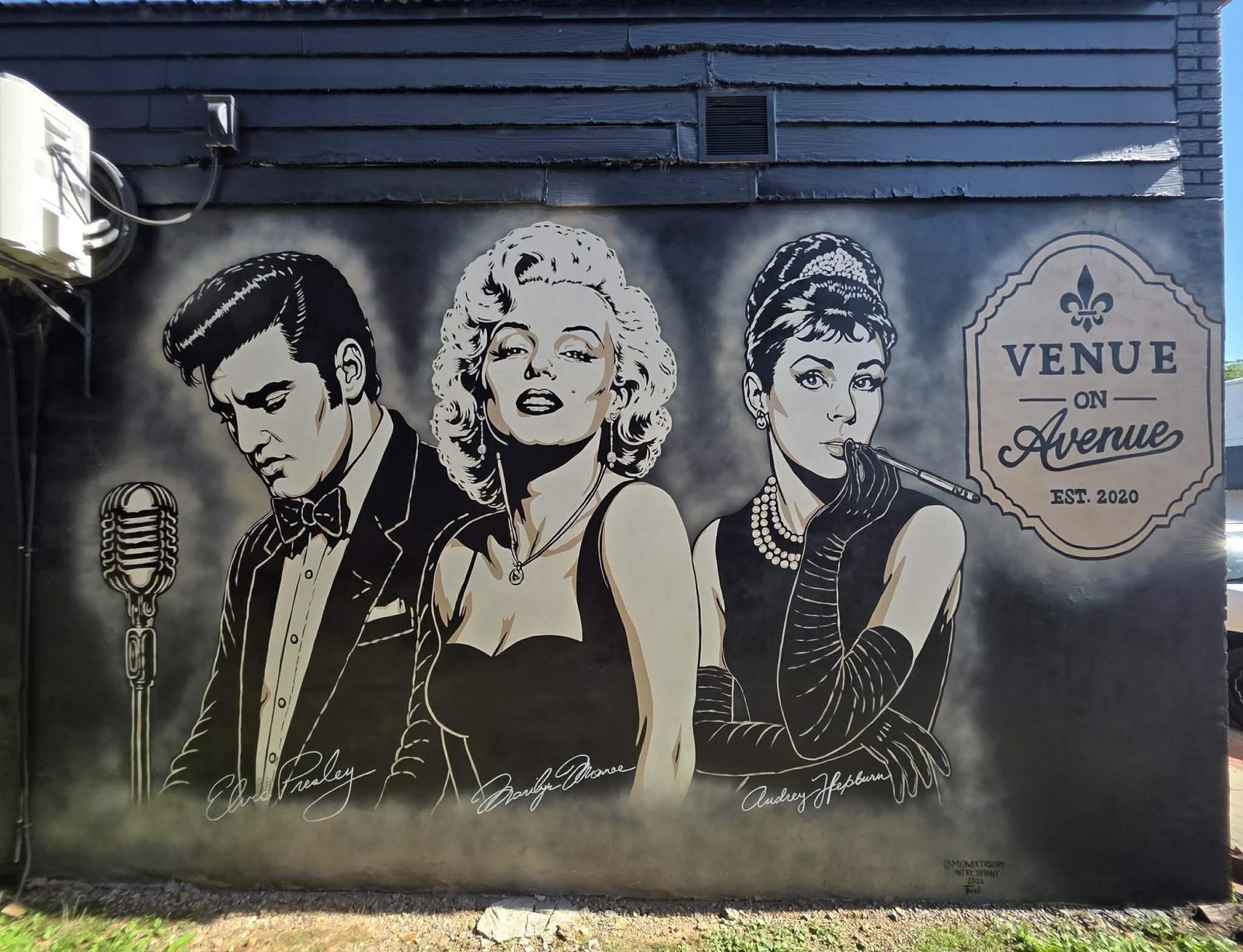 Venue on Avenue black-and-white pop-art mural of Elvis Presley, Marilyn Monroe, and Audrey Hepburn beside a vintage microphone and a 'Venue on Avenue — Est. 2020' sign