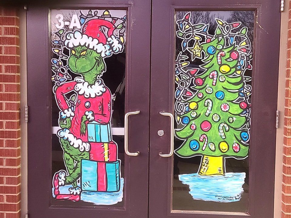 Holiday double-door painting featuring the Grinch in a Santa suit and a decorated Christmas tree