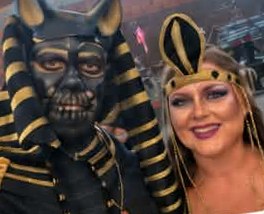 Couple in Egyptian Anubis and Cleopatra costumes with painted skull makeup